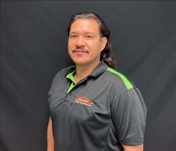 Man wearing a SERVPRO uniform in front of a black background