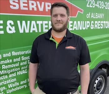 Male employee in front of service truck.