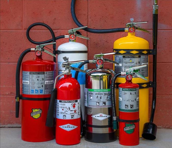 Multiple Fire Extinguishers with Brick Wall in Background